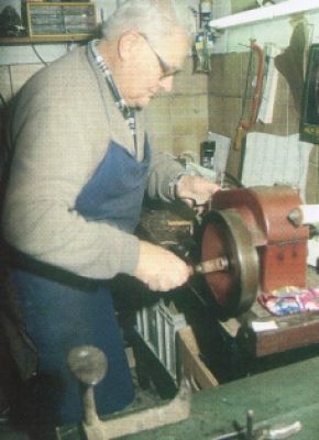 Aufdoppelmaschine“ /> </p>Die Qualität der Arbeit des Schusters hängt nicht nur von seinem handwerklichen Können, sonder auch vom vorhandenen Werkzeugsatz ab. In der Schuhflickwerkstatt von Alois Niederl liegen Schuhhackenschlager, Nietenschlager, die gebogene Kantenfeile für Zweispitznägel, Seitenschneider, Würstlschneider, Ahle (Ertl) gebogen und spitz, Bohrer, Vorsteherstupfer, Reibeisen für die Spitzzange, Texheber, Stifenschlager, Hammer, sohlenschere, Locheisen, Ösenstöckl, Dreifuß, Ständervorfuß und das Handleder. Daneben steht das Nährrössl, die handbetriebene Aufdoppelmaschine zum Nähen, der Schustertisch, der oft auf einer Erhöhung, die Schusterbruck’n genannt wird, steht der dreibeinige Schusterschemel.<br /><br />Die benötigten Holznägel wurden aus Lindenholz oder Birkenholz vom Schuster selbst geschnitzt, die notwendigen Bohrer aus alten Regenschirmspangerln zugeschliffen und der Schusterkneipp mit der Dreikantfeile geschliffen (geschärft) und mit dem Wetzstein nachbearbeitet. Kunststoffsohlen aus Amerika löste man nach dem 2. Weltkrieg in Azeton dünnflüssig zu einem Kleber auf. Auch die Leisten wurden in der eigenen Werkstätte geschnitzt. Vorerst erfolgte die grobe Zuschnitzung mit der Hand und die feine Formgebung dann mit der Holzraspel. Bei Standardleisten wurden diverse Vergrößerungen für unterschiedliche Fußgrößen durch Aufleimen von Leder und Stoff erreicht. <br /><br />Für die Holznagelherstellung wurden von einem Birkenholzstamm Scheiben abgeschnitten und in Wasser gekocht. Nach dem Trocknen wurden nagelstarke Riemen abgeschnitten, die man auf einer Seite zuspitze. Die einzelnen Nägel konnten jetzt der Reihe nach abgehackt werden. Verstärkt wurden die Schuhe durch metallene Mauskapperln (Nägel mit einem großen hervorstehenden gerillten Kopf), Herzblattn (Sohlenblattl), die auf die Sohle am Spitz oder Absatz kamen, Schiang’n (Flügelnägel), die hakenartig auf die Sohle seitlich geschlagen wurden und später die sechseckigen Pifflnägel, die den Mauskapperln ähnlich sind. <br /><br />In der Werkstätte sitzt der Schuster auf dem dreibeinigen Schusterschemel und der erhöhten Schusterbruck’n. Der alte Schusterschemel hatte ein längeres Hinterbein, das am Boden, und zwei kurze Beine, die erhöht auf der Schusterbruck’n standen. Der Grund für die kistenartige Erhöhung in der Werkstätte war die oftmals geöffnete Eingangstür, durch die kalte Luft in die Werkstatt zog. Indem der Schuster mit seinen Füßen auf der Schsuterbruck’n stand, blieben diese von der am Boden ziehenden Zugluft geschützt warm. „Schuster, die nicht auf der Schusterbruck’n arbeiten, haben immer kalte Füße“ weiß Fritz Semmlitsch, der heute eine Maßschuhmacherei in Takern bei St. Margarethen an der Raab betreibt, zu erzählen. <br /><br />Bereits als 12-jähriger Schüler musste Fritz Semmlitsch seinen Vater in <a title=